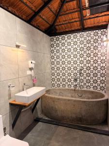 a bathroom with a large tub and a sink at Bhoomi by Ostello in Varkala +82 photos