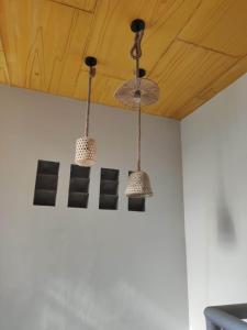 three lights hanging from a ceiling in a room at Bogartz Homestay in Mati
