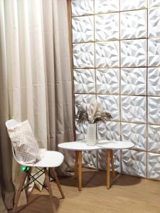 a table and a chair next to a wall at Bogartz Homestay in Mati +1 photo