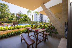an outdoor patio with a table and chairs and a pool at GAIA Hotel & Residence Phu Quoc in Phú Quốc