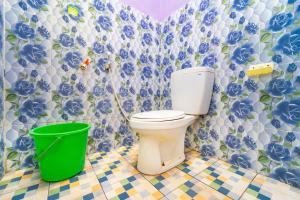 a bathroom with a toilet and a green bucket at Hotel Tiara By ARBA in Weleri +54 photos
