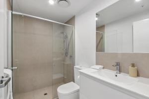 a bathroom with a shower and a toilet and a sink at The Corso - Central Maroochydore Apartment in Maroochydore