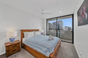 a bedroom with a bed and a large window at The Corso - Central Maroochydore Apartment in Maroochydore