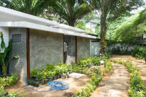 a house with a bunch of plants in a yard at Baan LungYod Resort in Phetchaburi