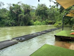 a river with a raft in the middle of it at Baan LungYod Resort in Phetchaburi