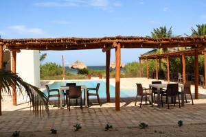 a patio with tables and chairs next to a pool at Club de Playa Sóol in Telchac Puerto