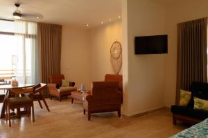 a living room with a table and a clock on a wall at Club de Playa Sóol in Telchac Puerto
