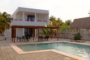 a house with a swimming pool in front of a house at Club de Playa Sóol in Telchac Puerto