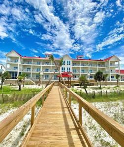 a boardwalk leading to a resort with a building at Driftwood Inn in Mexico Beach