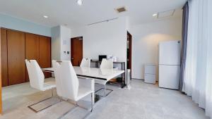 a dining room with a white table and white chairs at Fierement inn in Sapporo