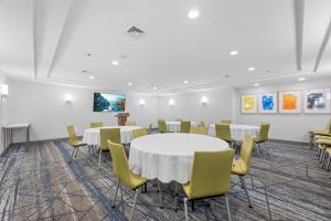 a conference room with white tables and yellow chairs at Holiday Inn Express Hartford-Newington by IHG in Newington +95 photos