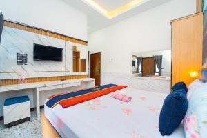 a bedroom with a bed with a flat screen tv at Hotel Tiara By ARBA in Weleri