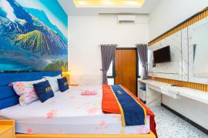 a bedroom with a bed with a mountain mural on the wall at Hotel Tiara By ARBA in Weleri