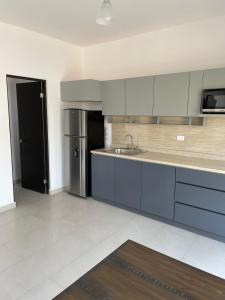 a kitchen with blue cabinets and a stainless steel refrigerator at Loftstay MYO in Monterrey