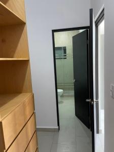 a bathroom with a toilet and a black door at Loftstay MYO in Monterrey +25 photos
