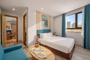 a hotel room with a bed and a blue couch at Lumina Hotel & Apartment in Danang +27 photos