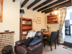a living room with a leather chair and a table at Merlin in Pwllheli