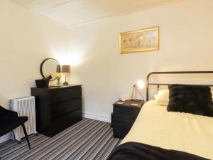 a bedroom with a bed and a dresser at Merlin in Pwllheli