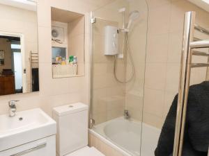 a bathroom with a shower and a toilet and a sink at Merlin in Pwllheli +12 photos