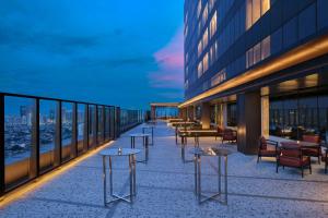 a row of tables on a balcony of a building at Aloft by Marriott Jakarta Kebon Jeruk in Jakarta