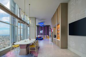 a lobby of a building with a table and chairs at Aloft by Marriott Jakarta Kebon Jeruk in Jakarta