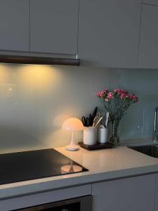 a kitchen with a lamp on a counter with flowers at CARTER Flat in Ho Chi Minh City +9 photos