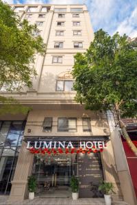 a building with a hotel sign in front of it at Lumina Hotel & Apartment in Danang