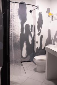 a bathroom with a shower curtain and a toilet at MESTO Koh Phangan - Creative Stay & Community Hub in Thong Sala +23 photos