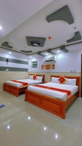 two beds in a room with two beds sidx sidx sidx at Khách Sạn FLORÉA in Phan Rang–Tháp Chàm