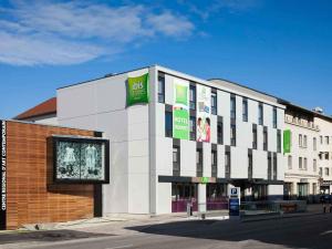 a white building with signs on the side of it at ibis Styles Montbéliard in Montbéliard