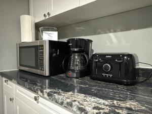 a microwave and a camera on a kitchen counter at Private Apartment for Business & Couples in Sudbury