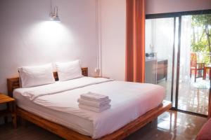 a bedroom with a bed with towels on it at MESTO Koh Phangan - Creative Stay & Community Hub in Thong Sala