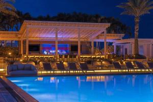 a pool with chairs and a bar at night at W Fort Lauderdale in Fort Lauderdale