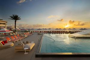 a resort with a pool with chairs and umbrellas at W Fort Lauderdale in Fort Lauderdale