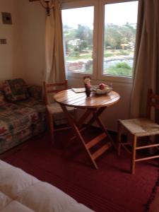 um quarto com uma mesa, uma cadeira e uma janela em Turquesa em El Quisco