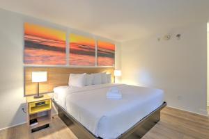 a bedroom with a bed and a painting on the wall at Hotel Carolina in Hilton Head Island +34 photos
