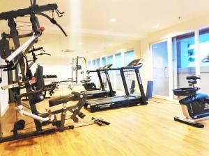 a gym with several tread machines in a room at Grand Kamala Lagoon by Whitebox in Bekasi