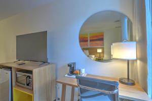 a room with a desk with a chair and a mirror at Hotel Carolina in Hilton Head Island