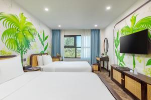 a hotel room with two beds and a flat screen tv at The Green Hotel Vientiane in Vientiane
