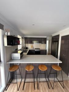 a kitchen with a counter and three stools at Weekend Escape in Rosebud