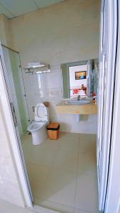 a bathroom with a toilet and a sink at Khách Sạn FLORÉA in Phan Rang–Tháp Chàm