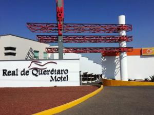 a sign in front of a building with a red and white sign at Motel Real de Queretaro in Querétaro