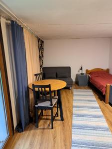 a room with a table and a couch and a bed at Lejas dzīvoklis Beči in Vecumnieki