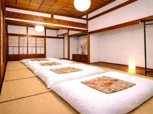 a large room with four beds in it at 里や 糸島 川遊び Bbq 花火を楽しむ古民家1棟貸し in Itoshima +17 photos