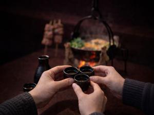 a person holding a cup in front of a fire at 里や 糸島 川遊び Bbq 花火を楽しむ古民家1棟貸し in Itoshima