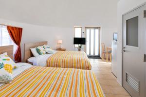ein Schlafzimmer mit zwei Betten und ein Wohnzimmer in der Unterkunft Uruma Dome Okinawa in Uruma