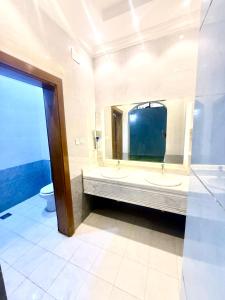 a bathroom with two sinks and a large mirror at شاليهات حياة روز in Taif