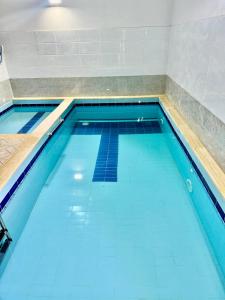 a swimming pool with blue water in a room at شاليهات حياة روز in Taif
