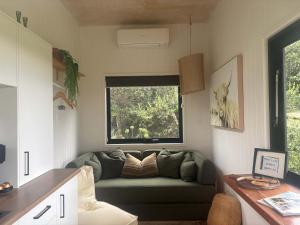 a living room with a couch and a window at Lily Pad Tiny Home in Maleny