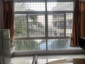 a window with a view of a building at Elysium Inn in Hyderabad